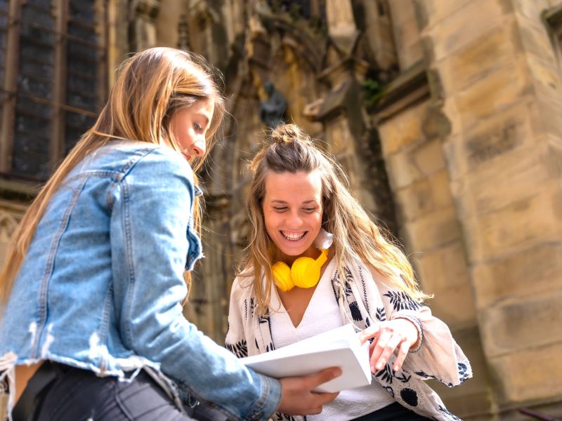 two-young-caucasian-women-in-the-city-reading-a.jpg