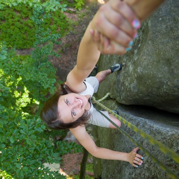 rockclimber-helping-to-female-climber-to-reach-.jpg